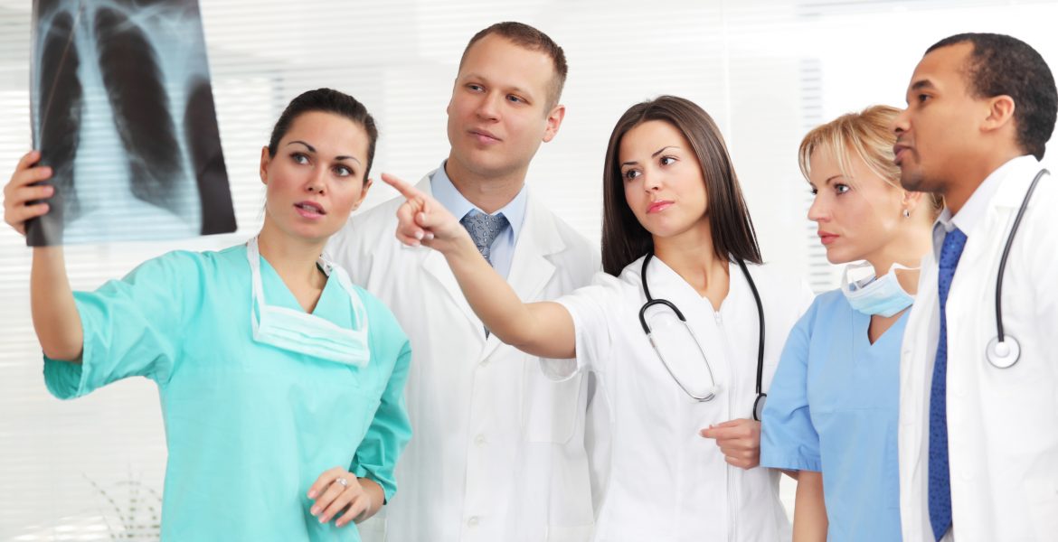 A large group of medical team, doctors and nurses are looking at patients x-ray. White background.